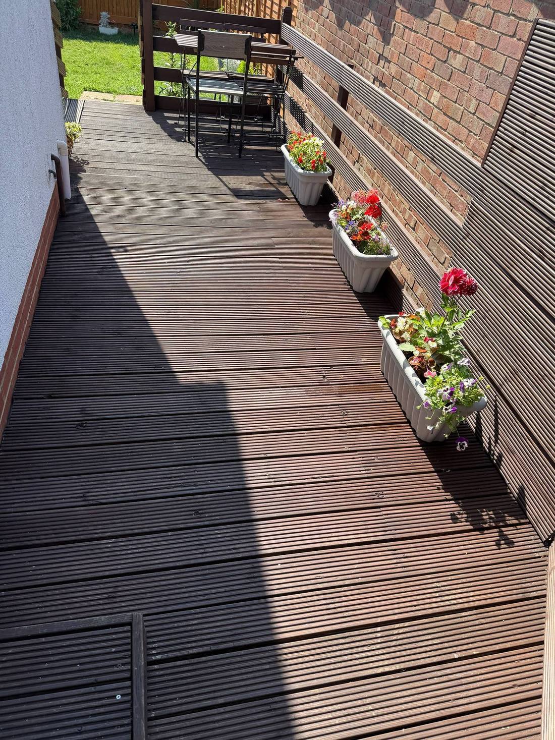 Sunny decked terrace with flowers at Bovingdon